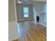 Bright living room featuring hardwood floors, a fireplace, and natural light from large windows at 3300 Neuse Crossing Dr, Raleigh, NC 27616