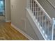 Staircase with gray carpet runner, white banister, and wood-look flooring in foyer at 3300 Neuse Crossing Dr, Raleigh, NC 27616