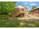 Charming brick home featuring a backyard with a wooden deck and stairs at 34 Johnston St, Pittsboro, NC 27312