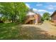 Backyard view of the home featuring a spacious yard, gravel area, and a wooden staircase at 34 Johnston St, Pittsboro, NC 27312