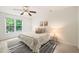 Bright bedroom featuring neutral paint, a ceiling fan, and a window showcasing a treed outdoor view at 34 Johnston St, Pittsboro, NC 27312