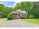 Quaint brick home featuring a well-kept lawn and a welcoming front entrance at 34 Johnston St, Pittsboro, NC 27312