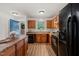 Well-lit kitchen boasting wood cabinets, black appliances, and updated flooring at 34 Johnston St, Pittsboro, NC 27312