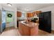 Kitchen with wood cabinets, black appliances, and a center island at 34 Johnston St, Pittsboro, NC 27312