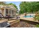 Backyard with stone patio, pool, lounge chairs and landscaping at 3821 Falls River Ave, Raleigh, NC 27614