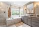 Bright bathroom boasts double sinks, granite countertops, a tiled shower, and a soaking tub, perfect for relaxation at 3821 Falls River Ave, Raleigh, NC 27614
