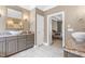 Bathroom features double sinks with granite countertops and tiled floor that leads to a connected bedroom at 3821 Falls River Ave, Raleigh, NC 27614