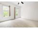 Bright room featuring two windows, neutral paint, white trim, plush carpet, and ceiling fan at 3821 Falls River Ave, Raleigh, NC 27614