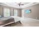 Spacious bedroom featuring carpeted floors, tray ceiling, natural light, and a TV at 3821 Falls River Ave, Raleigh, NC 27614