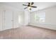 Bright, carpeted room features a window seat, neutral walls, ceiling fan and two doors at 3821 Falls River Ave, Raleigh, NC 27614
