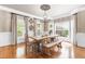 Bright dining room featuring large windows, wood floors and stylish chandelier at 3821 Falls River Ave, Raleigh, NC 27614