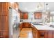 Kitchen boasts stainless steel appliances, wood cabinets, island cooktop, and hardwood floors at 3821 Falls River Ave, Raleigh, NC 27614