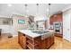 Kitchen island with gas cooktop and barstool seating, with access to stairs and dining room at 3821 Falls River Ave, Raleigh, NC 27614