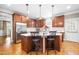 Kitchen with center island and barstool seating, stainless steel appliances, and hardwood floors at 3821 Falls River Ave, Raleigh, NC 27614