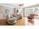Bright living room featuring hardwood floors, plush seating and large windows at 3821 Falls River Ave, Raleigh, NC 27614