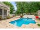 Outdoor pool and patio with stone pavers, surrounded by lush landscaping at 3821 Falls River Ave, Raleigh, NC 27614