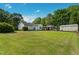 Expansive backyard featuring a well-manicured lawn, shade trees, carport, and outbuilding at 4022 Avents Ferry Rd, Sanford, NC 27330