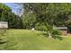 Green backyard featuring mature trees, birdhouses and multiple outbuildings for storage at 4022 Avents Ferry Rd, Sanford, NC 27330