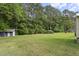 Large, green backyard featuring mature trees and multiple outbuildings perfect for storage at 4022 Avents Ferry Rd, Sanford, NC 27330