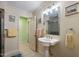 Bright bathroom featuring a pedestal sink, large mirror, and tiled floors with light neutral colored walls at 4022 Avents Ferry Rd, Sanford, NC 27330