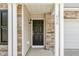 A close up of the front door shows stone work, door hardware, and house numbers at 430 Dogwood Creek Pl, Fuquay Varina, NC 27526