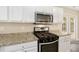 Close-up of a modern kitchen showcasing stainless steel oven, microwave, and granite counters at 430 Dogwood Creek Pl, Fuquay Varina, NC 27526