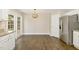 Bright kitchen with stainless steel refrigerator, white cabinets, and hardwood floors at 430 Dogwood Creek Pl, Fuquay Varina, NC 27526