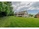 Expansive backyard with a well-maintained lawn and partial view of the home's rear exterior and deck at 4667 Freedom Dr, Burlington, NC 27215
