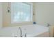 Bright bathroom features a relaxing soaking tub with a glass block window, creating a spa-like atmosphere at 4667 Freedom Dr, Burlington, NC 27215