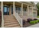 Close up of the brick stairs leading to front porch with white railings and columns at 4667 Freedom Dr, Burlington, NC 27215