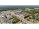 A vibrant aerial view displays commercial buildings, busy roads, and lush surrounding greenery at 48 Arlington Dr, Cameron, NC 28326