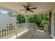Spacious covered back porch with wooden deck, ceiling fan, and view of lush greenery at 48 Arlington Dr, Cameron, NC 28326