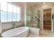 Bright bathroom with a freestanding tub, glass-enclosed shower, and access to a walk-in closet at 4921 Sweetbriar Dr, Raleigh, NC 27609