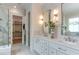 Luxurious bathroom featuring a double vanity, decorative mirrors, and a doorway to a walk-in closet at 4921 Sweetbriar Dr, Raleigh, NC 27609