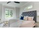 Bright bedroom with a large bed, stylish headboard, and a view of the landscaped yard at 4921 Sweetbriar Dr, Raleigh, NC 27609