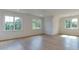 Bright bedroom featuring hardwood flooring, a modern ceiling fan, recessed lighting, and oversized windows with exterior views at 4921 Sweetbriar Dr, Raleigh, NC 27609