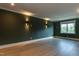 Spacious bedroom with modern lighting fixtures, hardwood flooring, and large windows with views of lush greenery at 4921 Sweetbriar Dr, Raleigh, NC 27609