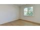 Light-filled bedroom with hardwood floors and a large window overlooking the backyard at 4921 Sweetbriar Dr, Raleigh, NC 27609