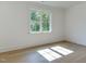 Bright bedroom featuring a large window with backyard views, hardwood flooring, and white walls for a serene retreat at 4921 Sweetbriar Dr, Raleigh, NC 27609