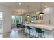 Bright kitchen with a large island, barstool seating, modern lighting, and an adjacent dining area with natural light at 4921 Sweetbriar Dr, Raleigh, NC 27609