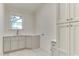 Bright laundry room with sleek cabinetry, ample counter space, and a window offering natural light for a functional workspace at 4921 Sweetbriar Dr, Raleigh, NC 27609