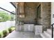 Outdoor kitchen with stone walls, grill, sink, stainless steel appliances, and countertop at 4921 Sweetbriar Dr, Raleigh, NC 27609