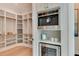 Custom walk-in closet with built-in shelving, drawers, and hanging racks, plus a built-in coffee maker and beverage fridge at 4921 Sweetbriar Dr, Raleigh, NC 27609