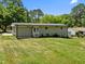 Back exterior showcasing a well-maintained lawn, a back staircase, and mature landscaping at 5208 Melbourne Rd, Raleigh, NC 27606