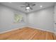 Bright bedroom featuring hardwood floors, a ceiling fan, and a window with natural light at 5208 Melbourne Rd, Raleigh, NC 27606