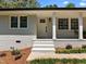 Close-up of the front porch with white brick, columns, and a seating area adjacent to the main entry door at 5208 Melbourne Rd, Raleigh, NC 27606
