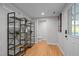 Hallway with wood floors, decorative shelving, and view of a toilet at 5208 Melbourne Rd, Raleigh, NC 27606