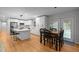 Modern kitchen with white cabinets, stainless appliances, island with seating, and adjacent dining area at 5208 Melbourne Rd, Raleigh, NC 27606