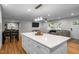 Open-concept living area with a modern kitchen island, dining table, and comfortable seating area at 5208 Melbourne Rd, Raleigh, NC 27606