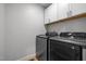 Well-equipped laundry room with modern washer and dryer, plus ample cabinet storage space at 5208 Melbourne Rd, Raleigh, NC 27606